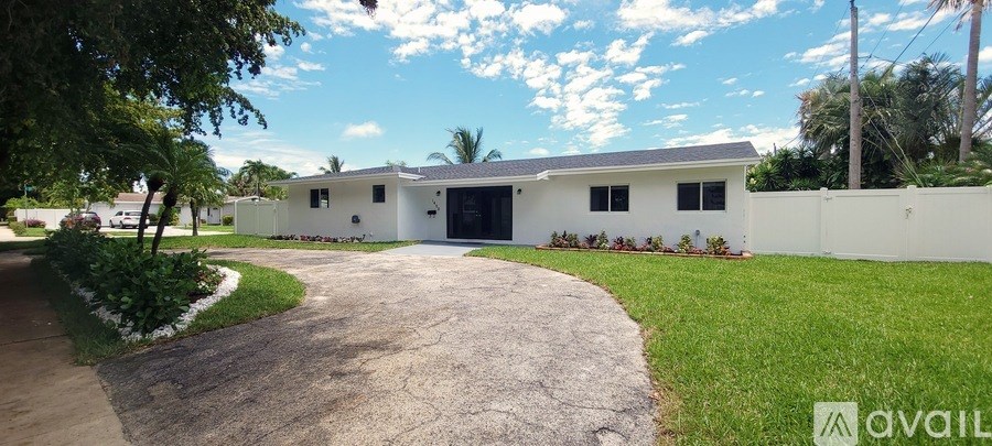 A white house with a driveway in front of it.