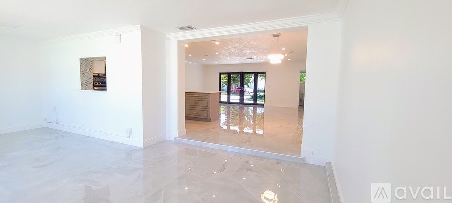 A spacious room with a large mirror and a painting on the wall.