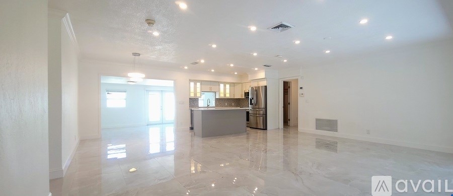 A spacious, empty room with marble flooring and white walls.
