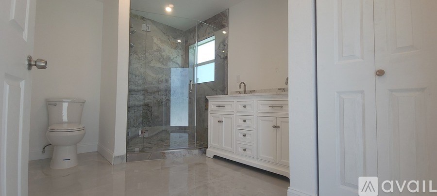 A bathroom with a toilet, sink, and a walk-in shower.