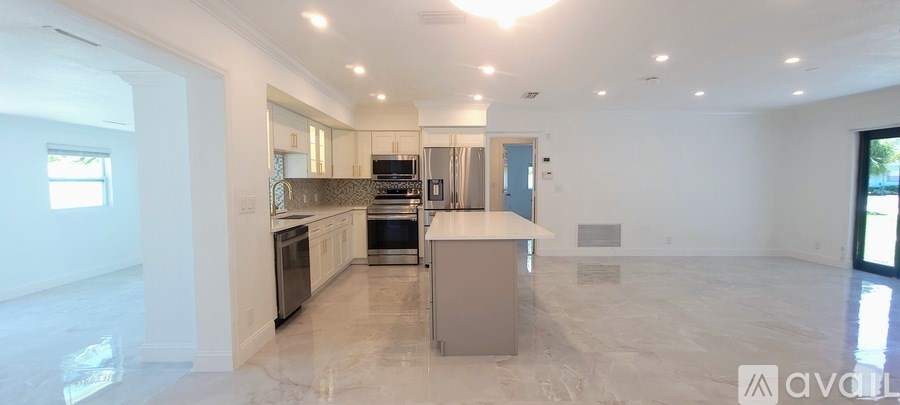 A spacious kitchen with a marble countertop and a large island.