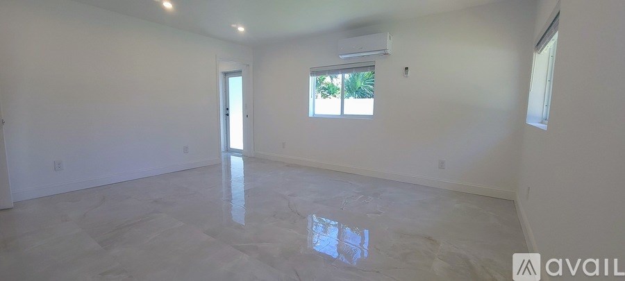 A spacious room with a large window and a tiled floor.