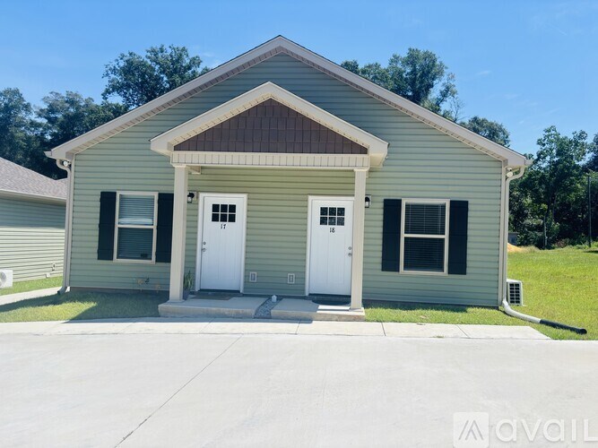 A house with a brown roof and a white door is for sale.