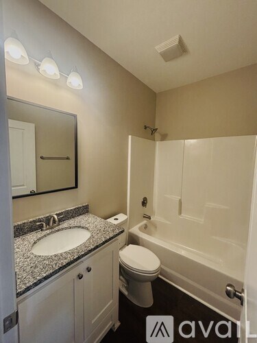 A bathroom with a sink, toilet, and bathtub.