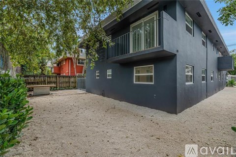 A modern house with a balcony and a gravel driveway.