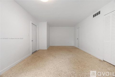 A room with white walls and a carpeted floor.