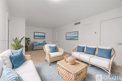 A living room with white furniture and blue cushions.