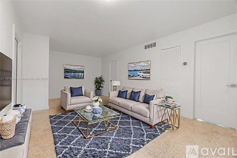 A living room with a sofa, a coffee table, and two pictures on the wall.