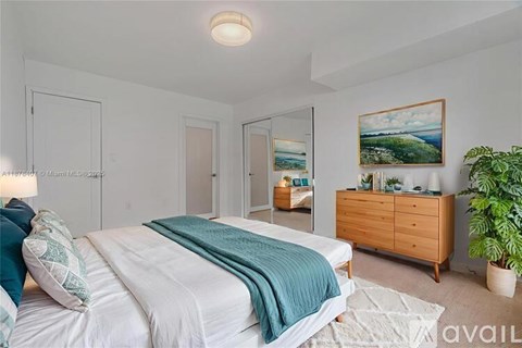 A bedroom with a bed, dresser, and a painting on the wall.