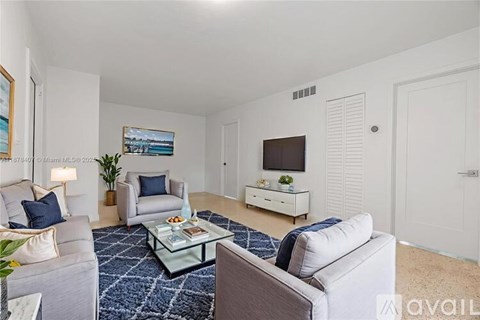 A living room with a grey sofa, a white armchair, a glass coffee table, and a painting on the wall.