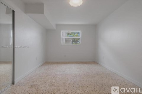 A room with a window and a picture on the wall.