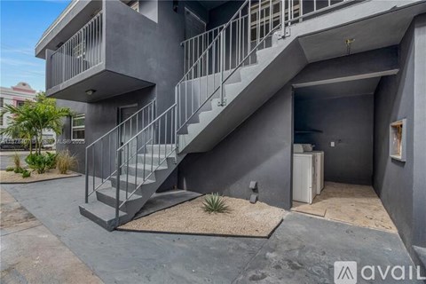 A modern house with a grey exterior and a staircase leading to the upper level.
