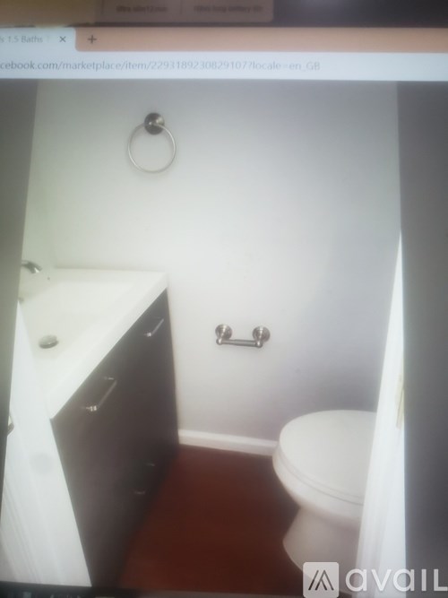 A small bathroom with a toilet, sink and cabinet.