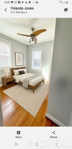 A bedroom with a bed, nightstand, and a ceiling fan.