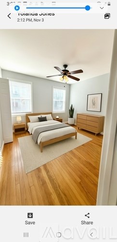 A bedroom with a bed, dresser, and ceiling fan.