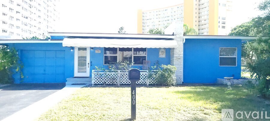 A blue house with a white picket fence in front.