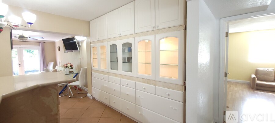 A kitchen with white cabinets and a brown counter.
