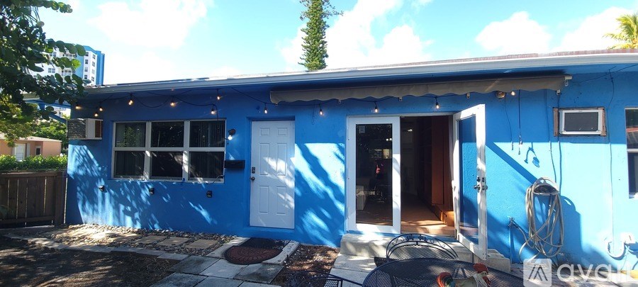 A blue house with a white door and windows.