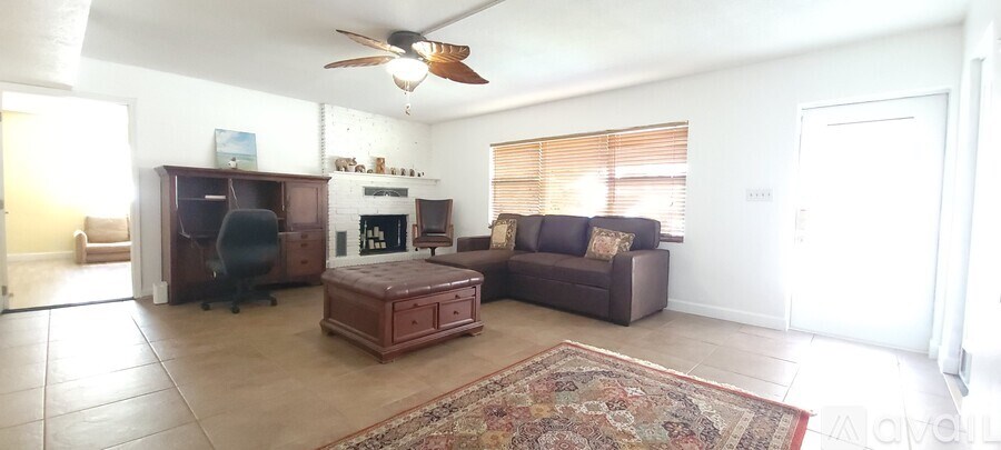 A living room with a fireplace and a brown couch.