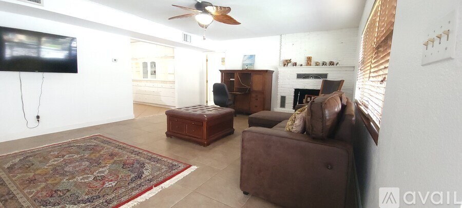 A living room with a rug and a flat screen TV.
