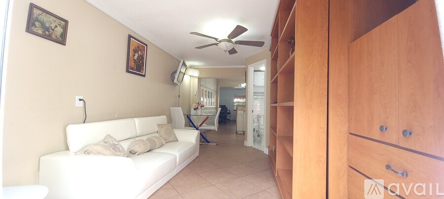 A living room with a white couch and a ceiling fan.