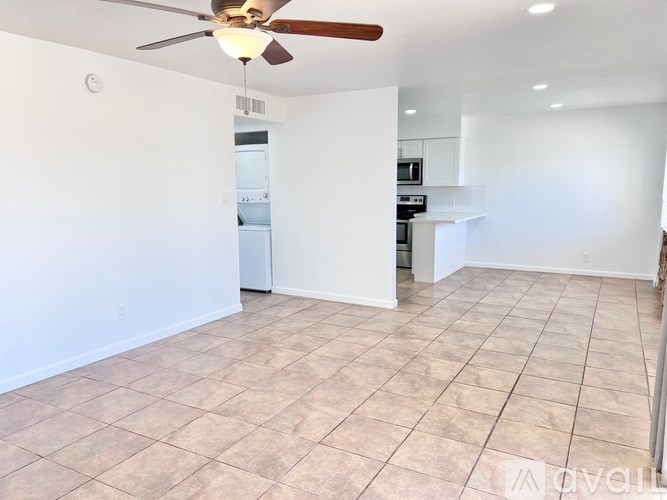 A room with a ceiling fan and tiled flooring.