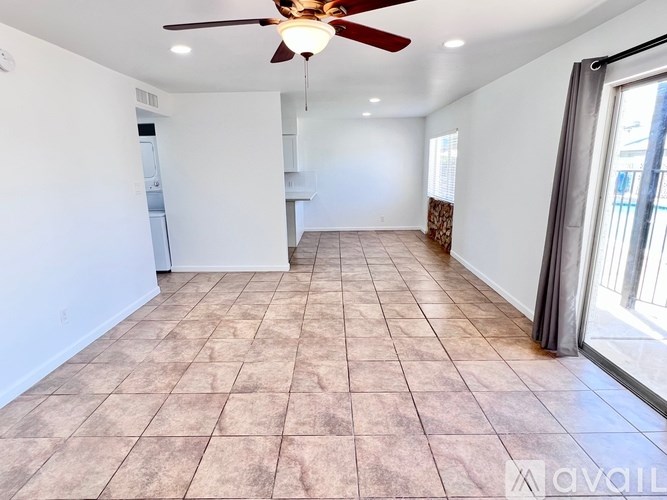 A spacious room with a ceiling fan and tiled flooring.