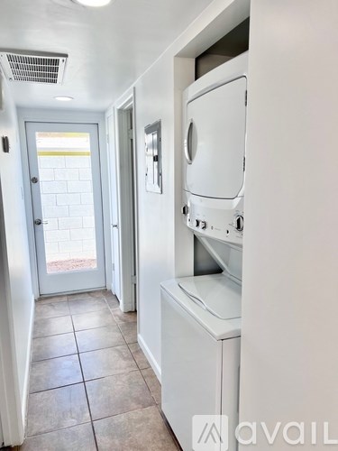 A white washing machine is in a small laundry room.
