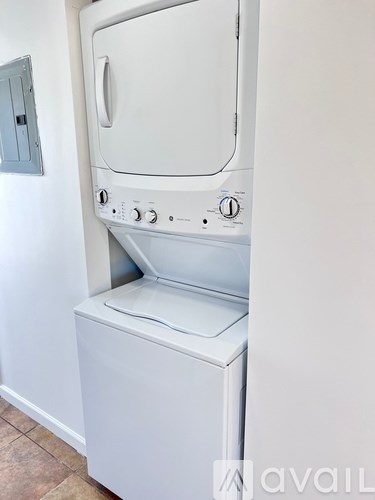 A white oven with a door and control panel is installed in a wall.