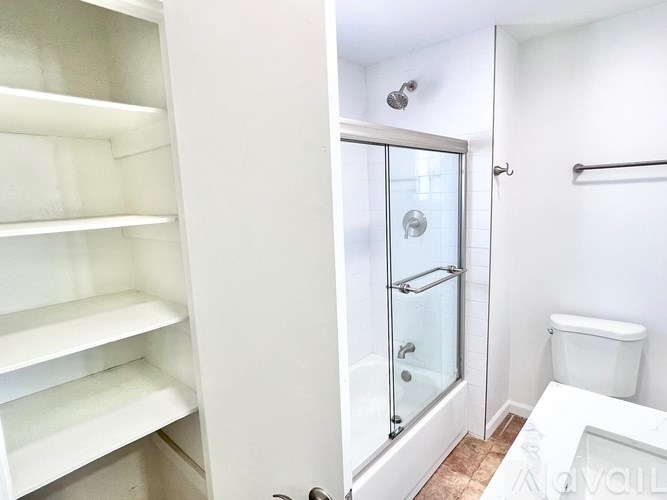 A white bathroom with a walk in shower and toilet.