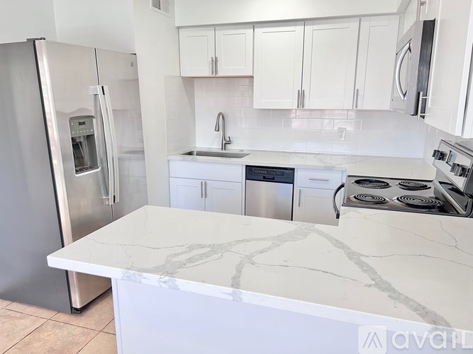 A kitchen with a marble countertop and stainless steel appliances.
