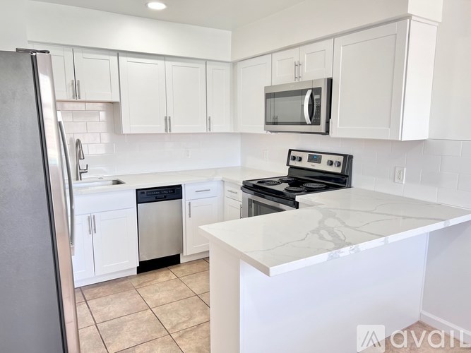 A kitchen with white cabinets and a black stove top.