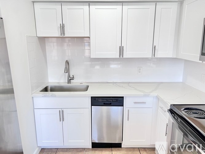 A kitchen with white cabinets and a black stove top.