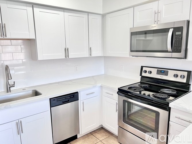 A kitchen with white cabinets and a black stove top.