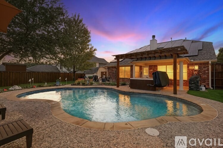 A backyard with a pool and a house.