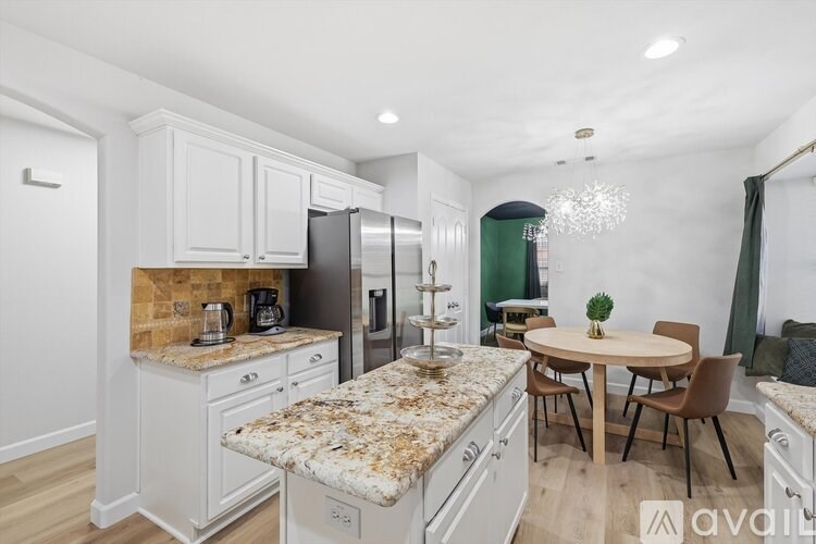A kitchen with granite countertops and a table set for two.