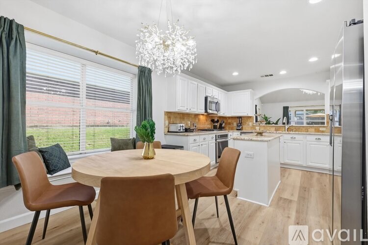 A modern kitchen with a dining table and chairs.