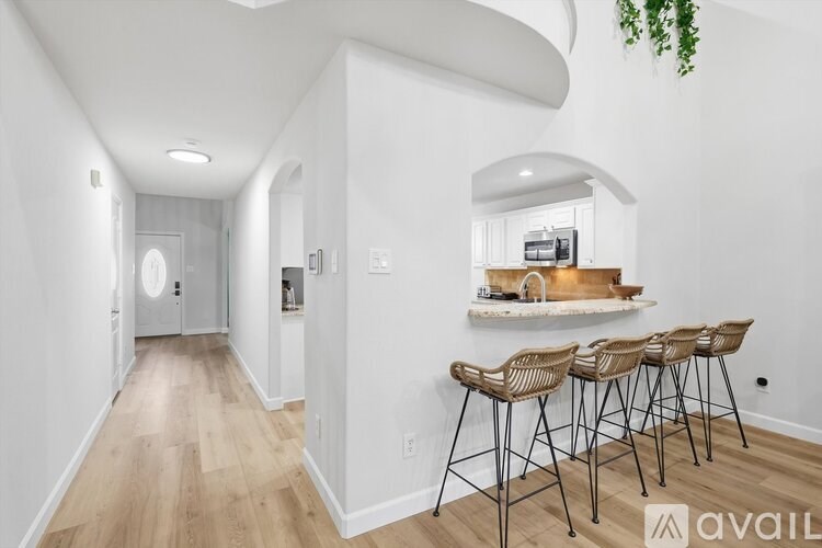 A long hallway with a bar and chairs at the end.