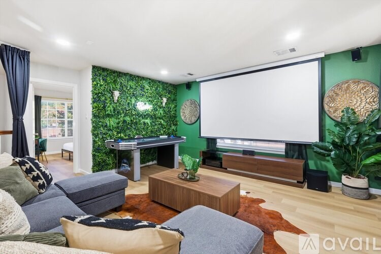 A living room with a pool table and a green wall.