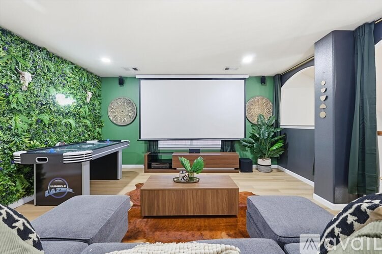 A living room with a green wall and a pool table.