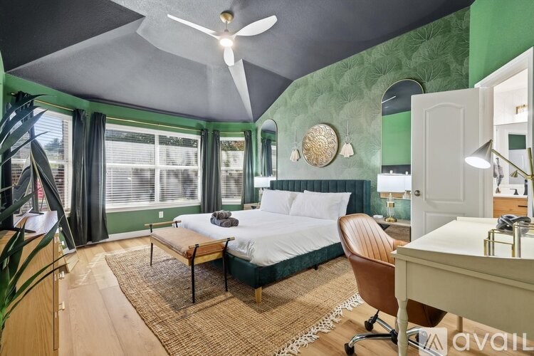 A bedroom with a bed, chair, and desk.