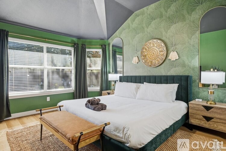 A bedroom with a large bed and a wooden bench in front of it.