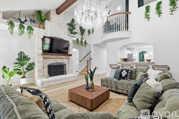 A living room with a fireplace and a TV mounted above it.