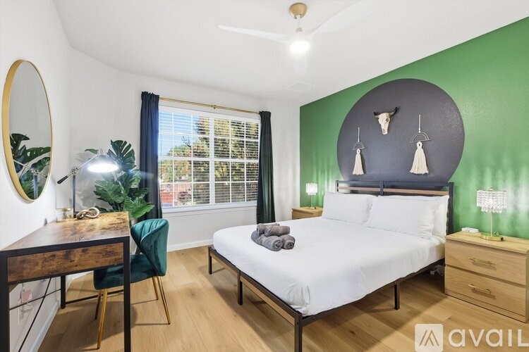 A bedroom with a bed, desk, and chair.