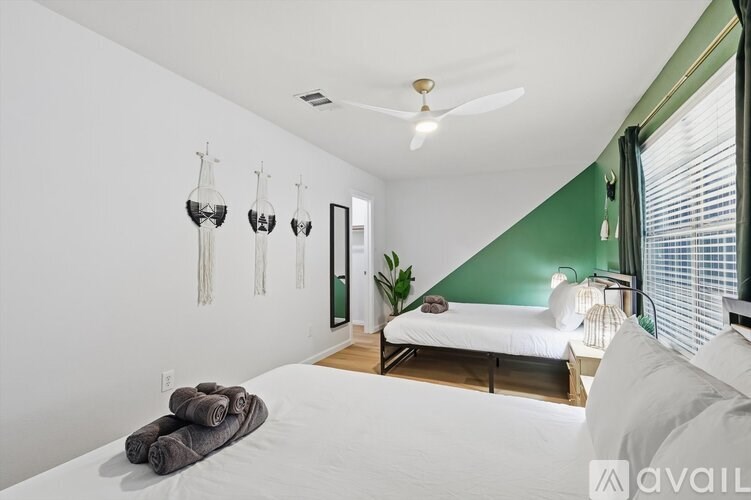 A bedroom with a bed, a ceiling fan, and a plant.