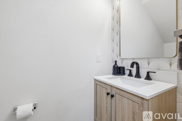 A bathroom with a white sink and a mirror above it.