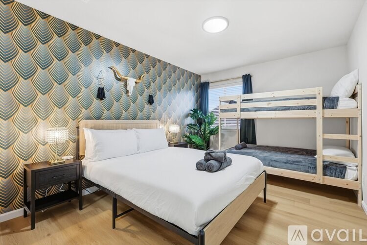 A bedroom with a patterned wallpaper and a bunk bed.