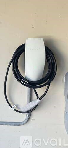A white power adapter with a black cord.