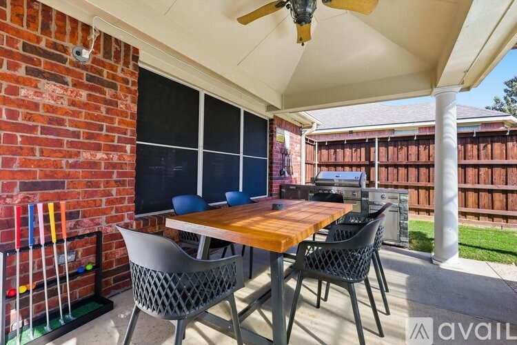 A patio with a table and chairs under a white awning.
