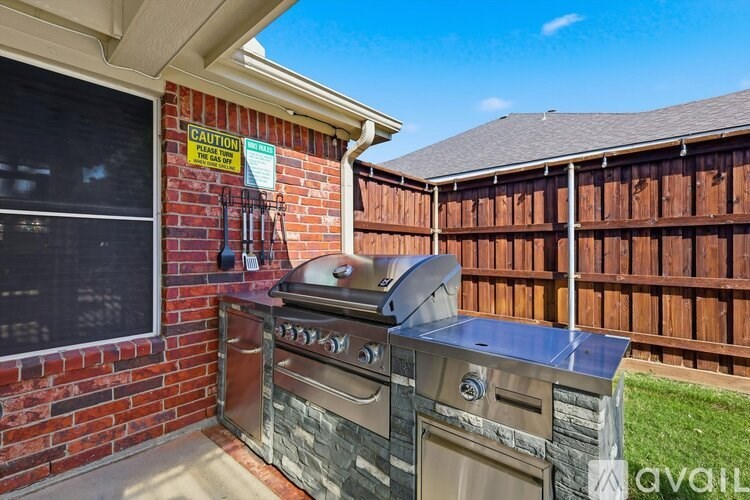 A grill and a trash can are on a patio.